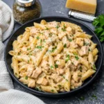 Creamy Garlic Chicken Pasta in a black bowl with parsley and glossy Parmesan sauce