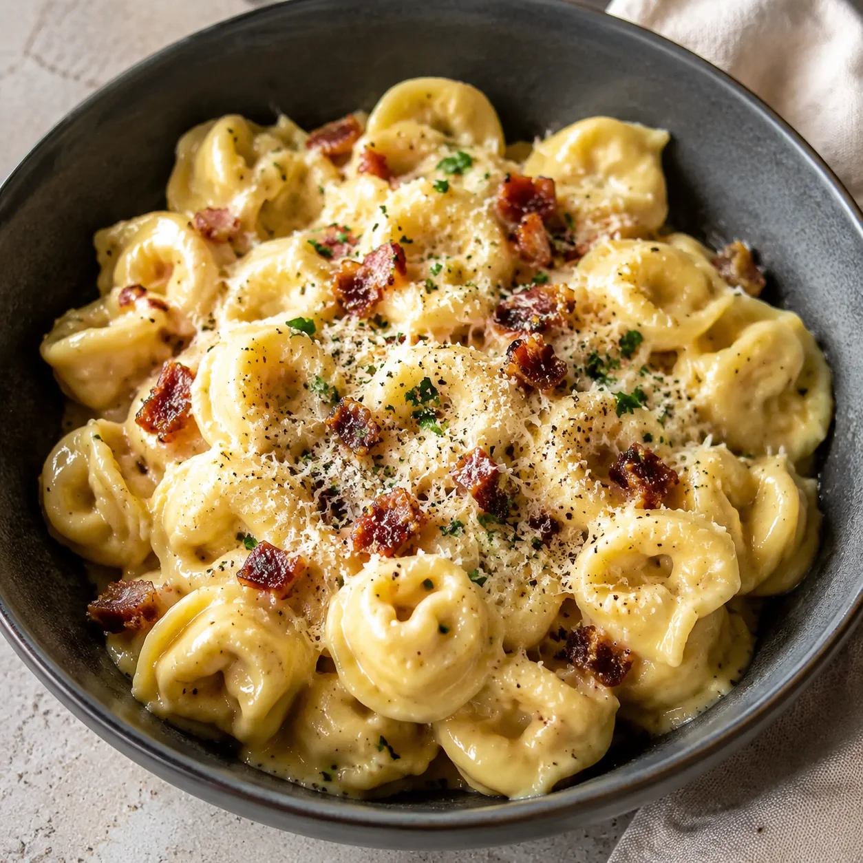 Creamy Tortellini Carbonara Recipe (30-Minute) with creamy pasta, crisp bacon, and parsley in a bowl