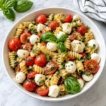 Fresh Caprese Pasta Salad with glossy tortellini, mozzarella pearls, basil, and juicy tomatoes